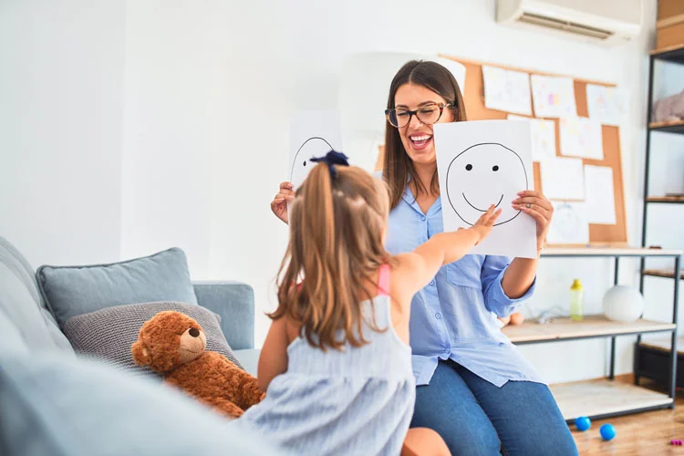 Un enfant chez un psychologue montrant un smiley sur une feuille